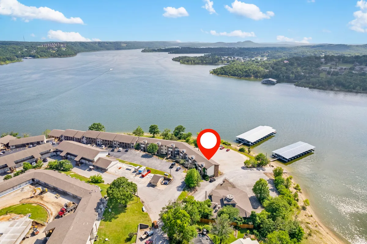 A wide exterior view shows the lake, boats, a residential complex, and lush landscaped gardens. The tranquil, community-oriented mood highlights spaces for social gatherings, relaxation, and lakeside fun—perfect for groups or families.
